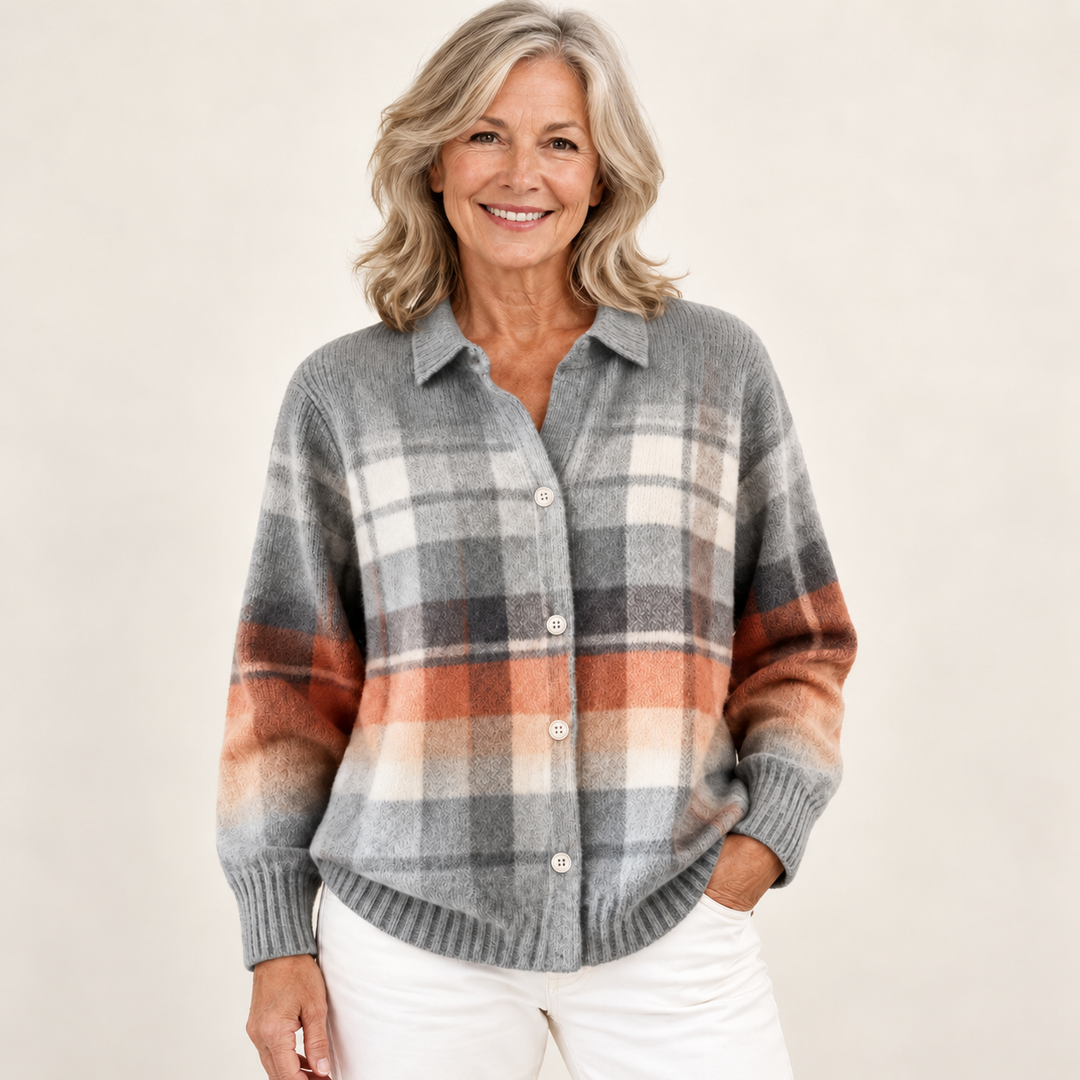 Mature British woman wearing the ELIRA checked blouse on a clean warm off-white studio background