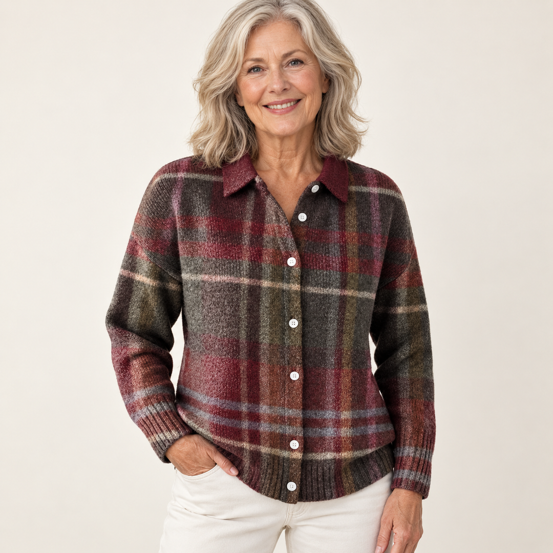 Mature British woman wearing the EMELYN checked blouse on a clean warm off-white studio background