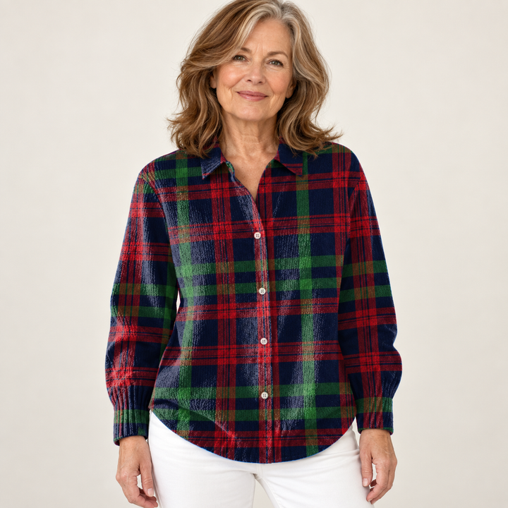 Mature British woman wearing the GUNELLE blouse on a clean warm off-white studio background