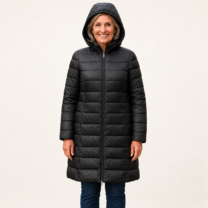 Mature British woman wearing the HELSA Black padded jacket on a clean warm off-white studio background