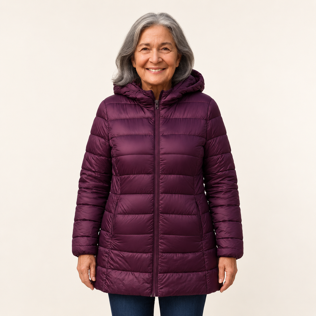 Mature British woman wearing the HELSA Purple padded jacket on a clean warm off-white studio background
