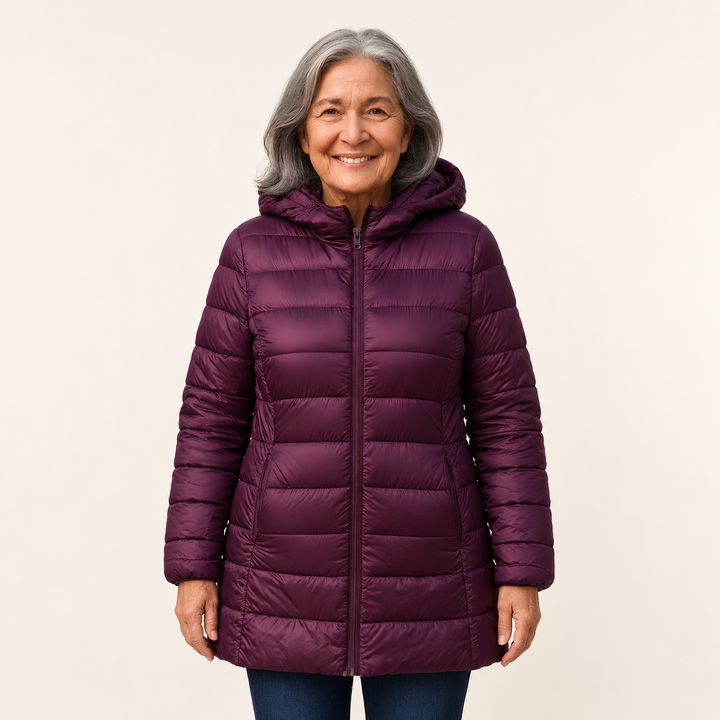 Mature British woman wearing the HELSA Purple padded jacket on a clean warm off-white studio background