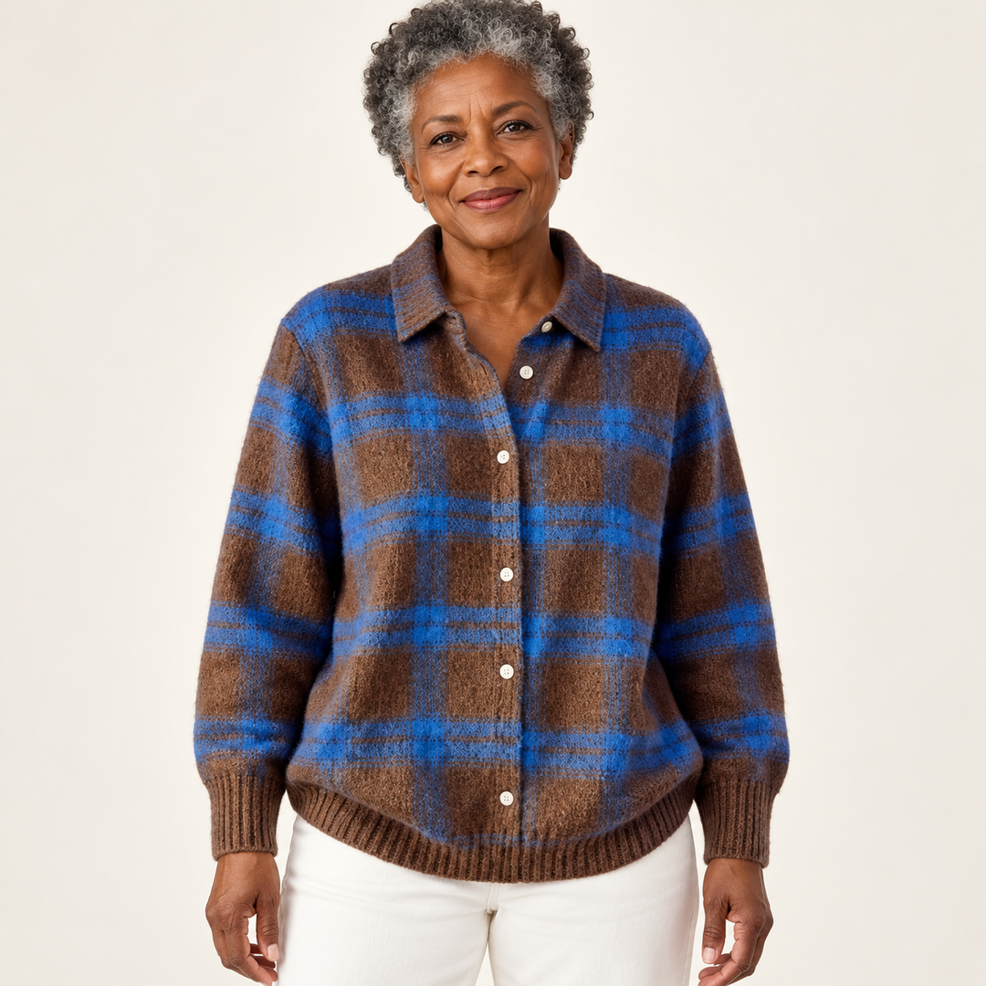 Mature British woman wearing the LIZZA blouse on a clean warm off-white studio background