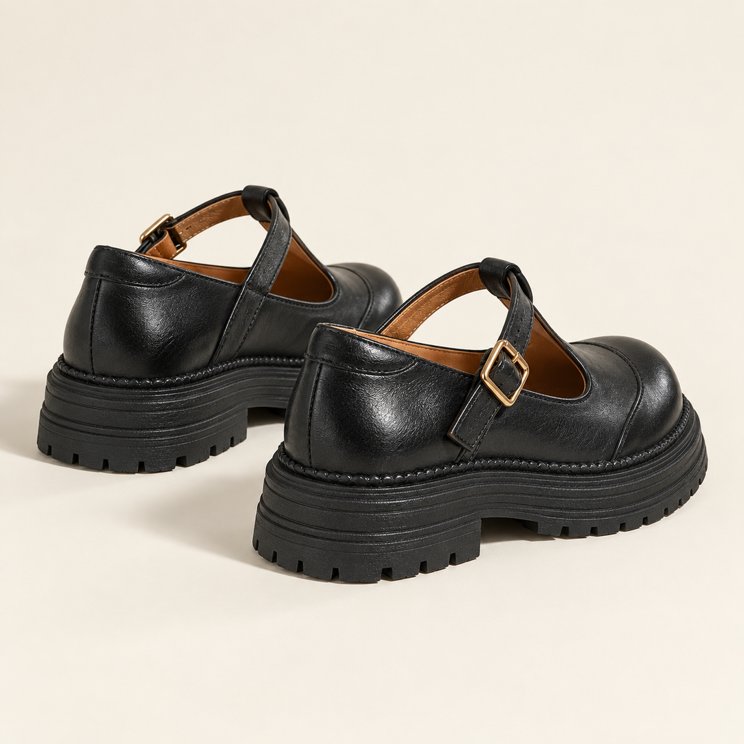 Black T-strap Mary Jane shoes, clean studio rear three-quarter view