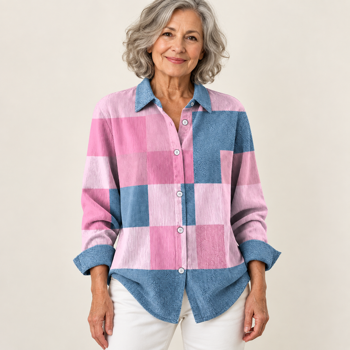 Mature British woman wearing the NORAYA blouse on a clean warm off-white studio background