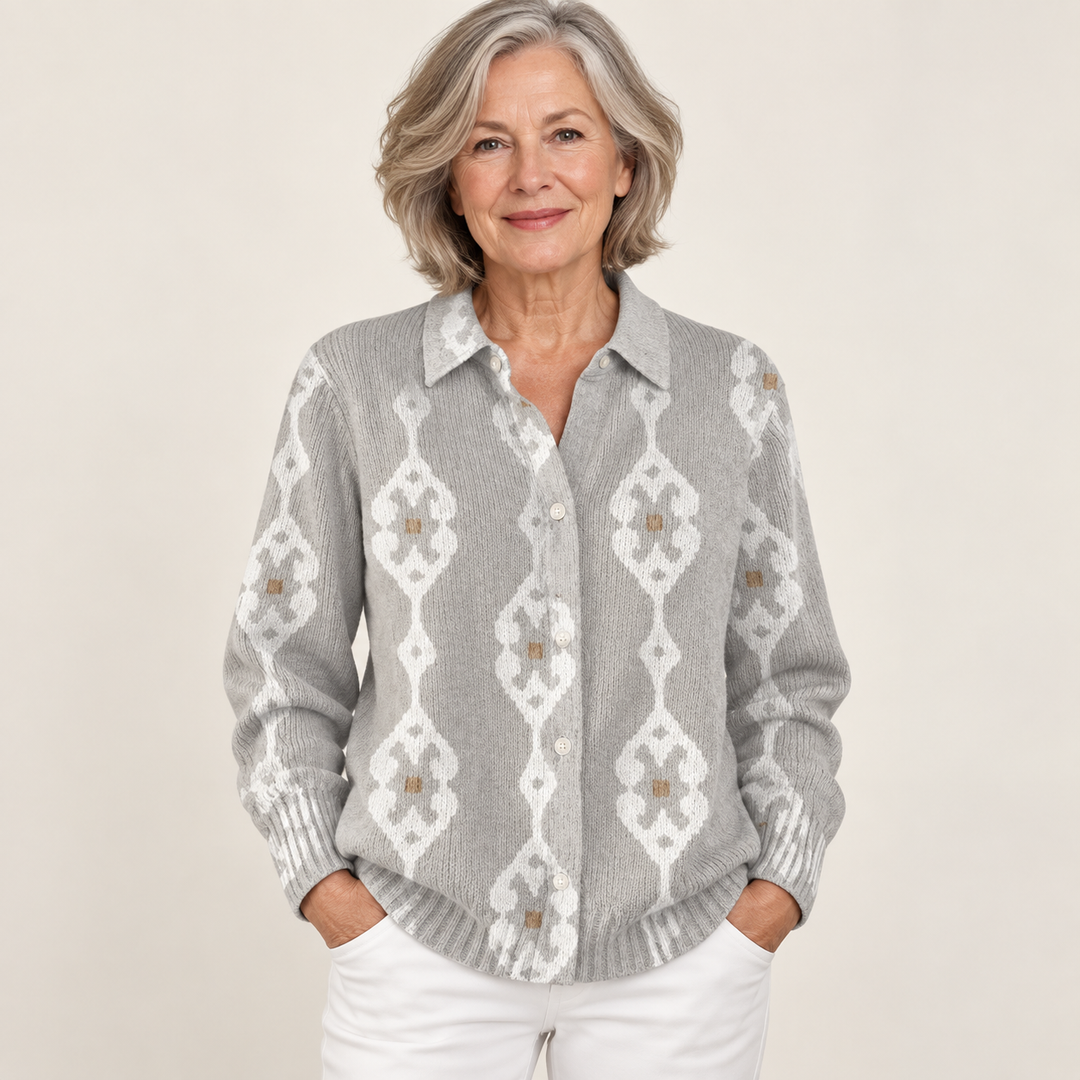 Mature British woman wearing the RENAE blouse on a clean warm off-white studio background