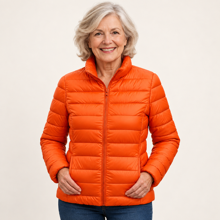 Ulla transitional padded jacket in Orange worn by a mature woman, natural studio pose